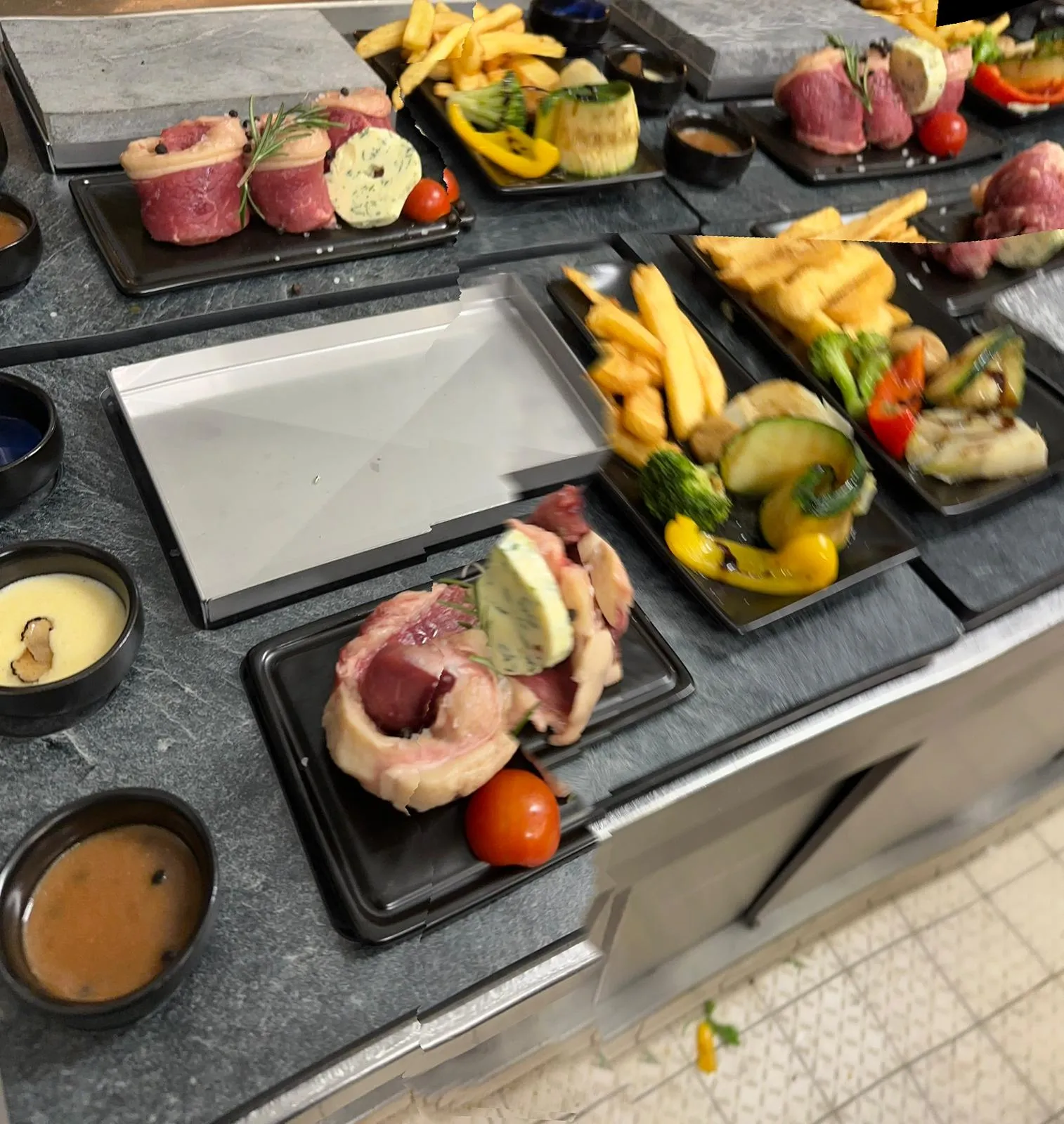 Servierfertige heiße Steine mit Beilagen für Steak auf heißem Stein